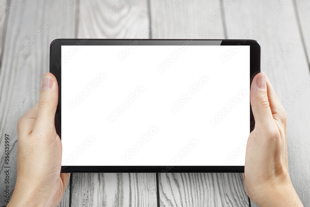 Hands holding black tablet on white wooden background