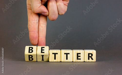 Better or bitter symbol. Concept word Better and Bitter on wooden cubes. Businessman hand. Beautiful grey table grey background. Business and better or bitter concept. Copy space.