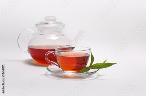 Tea cup and glass teapot on light background.