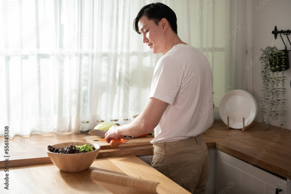 An Asian young man cooking , preparing breakfast with healthy food in kitchen at home , healthy lifestyle An Asian young man cooking , preparing breakfast with healthy food in kitchen at home , healthy lifestyle