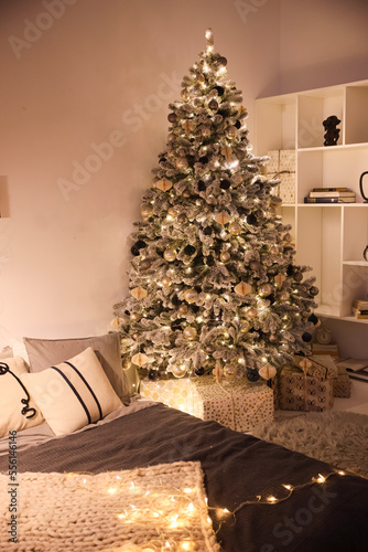 The room is decorated in a New Year's style with a Christmas tree and toys