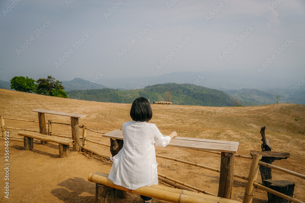 person sitting on a bench and looking mountains view. Traveling concept.