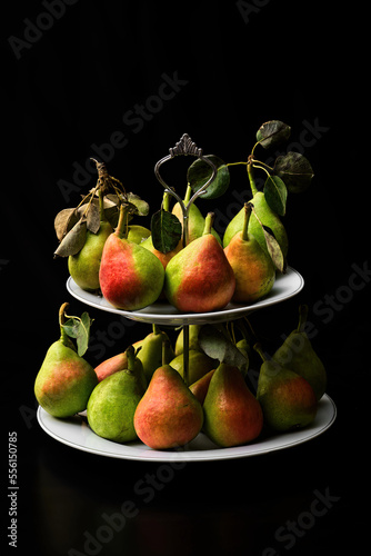 Pere in portafrutta su sfondo nero