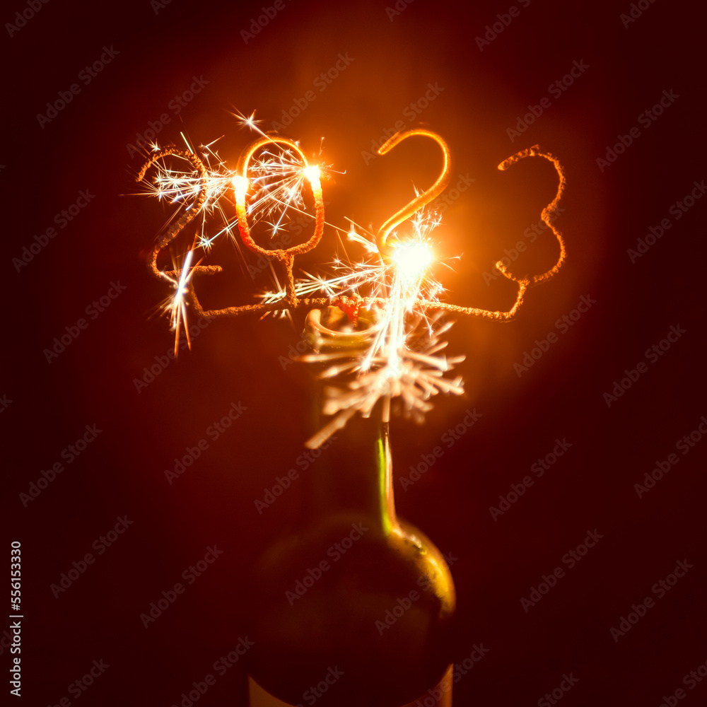 2023 Shaped Sparkler igniting in Wine Bottle, outdoors at night. Selective focus.
