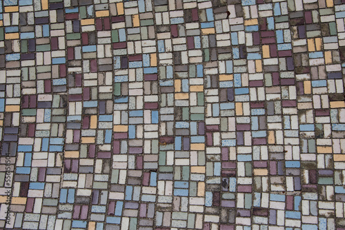 Mosaic of old colored ceramic tiles. Floor covering.