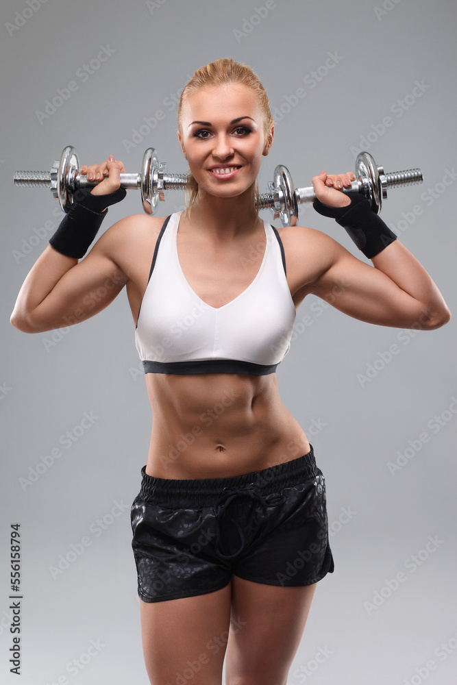 sporty muscular woman working out with dumbbells sporty muscular woman working out with dumbbells
