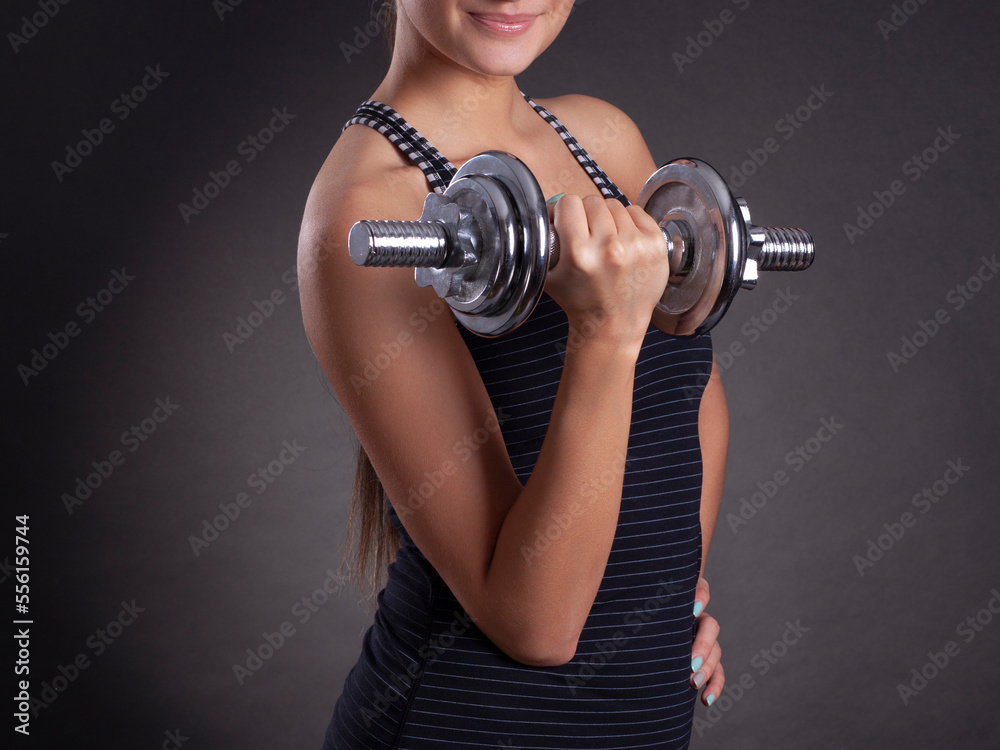 sporty muscular woman working out with dumbbells