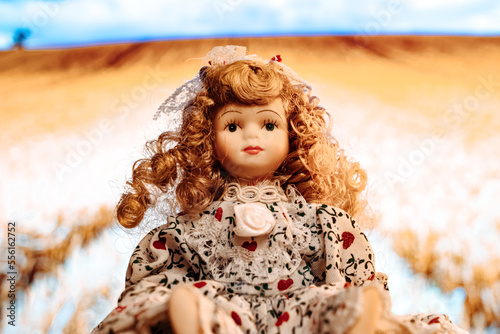 ceramic porcelain doll on blurred filed background
