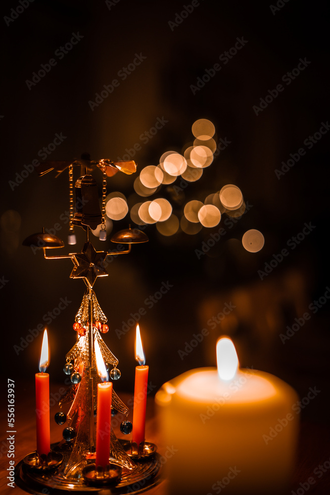 Christmas candles and Christmas bell. In background Christmas tree. Christmas candles and Christmas bell. In background Christmas tree.