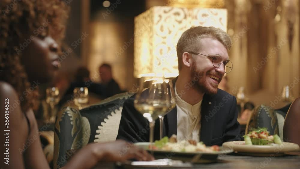 happy people of different races and ethnicities having fun together in festival dinner in restaurant