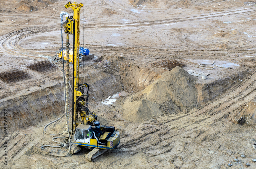 Drilling rig in a pit at a construction site. Deep foundation machine for foundation works. Groung drilling for concrete placing into the borehole Drilling rig in a pit at a construction site. Deep foundation machine for foundation works. Groung drilling for concrete placing into the borehole
