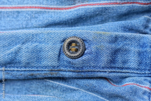 one small brown metal button on a blue fabric