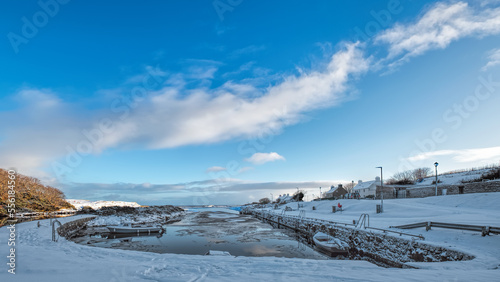 Brora harbour with winter snow and blue sky