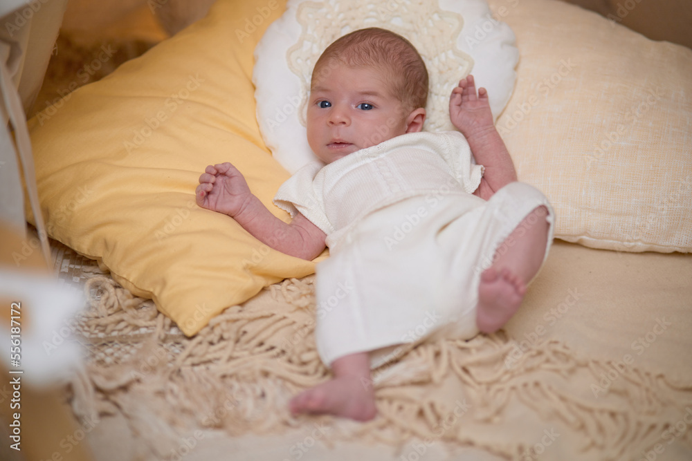 Newborn baby for the first time at home, lying in a blanket on the bed, smiling, yawning, pulling pens, falling asleep, baby's morning, baby products concept Newborn baby for the first time at home, lying in a blanket on the bed, smiling, yawning, pulling pens, falling asleep, baby's morning, baby products concept