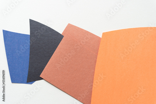 overlapping squarish construction paper shapes on a blank paper background