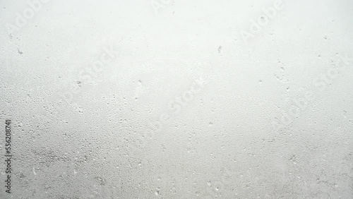 窓ガラスに打ち付ける雪の氷