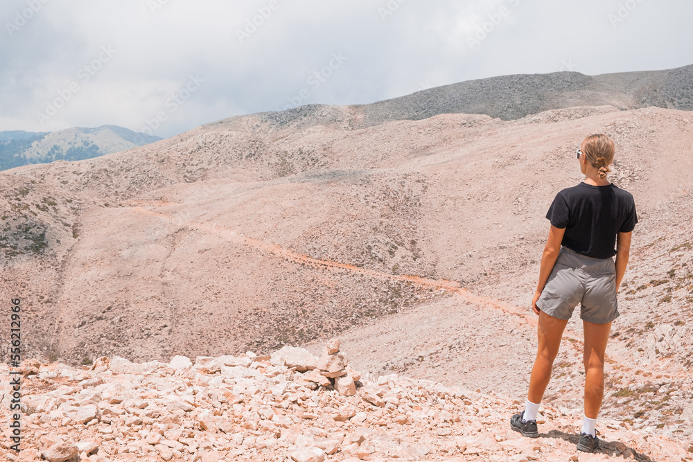 The girl stands on the edge of a high mountain in the clouds. The girl looks at the beautiful mountain landscape Antalya Turkey The girl stands on the edge of a high mountain in the clouds. The girl looks at the beautiful mountain landscape Antalya Turkey
