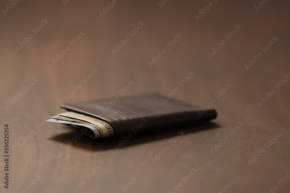 Bespoke brown all leather wallet on walnut table with cash Bespoke brown all leather wallet on walnut table with cash
