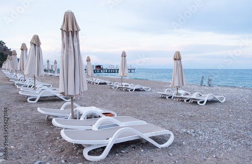 many sunbeds with umbrellas on the shores of the azure sea vacation by the sea © Ketrin