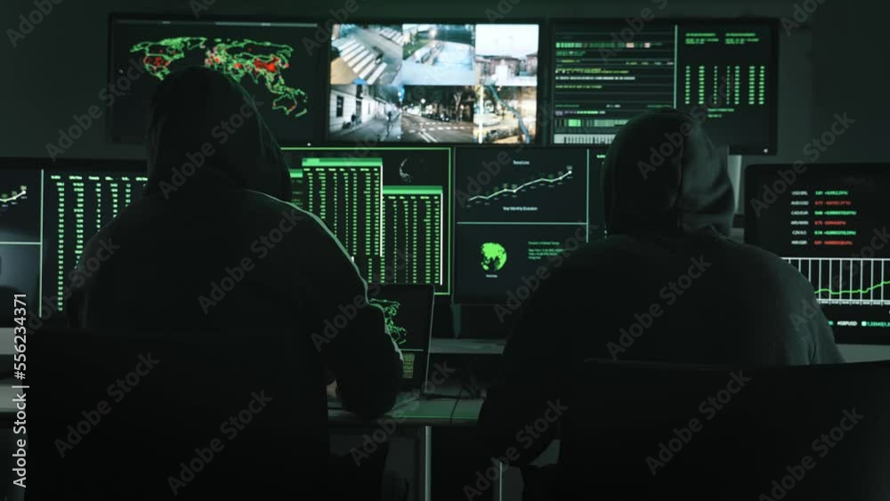 Team of unrecognizable Computer hackers coding and using monitor screens to program security breach