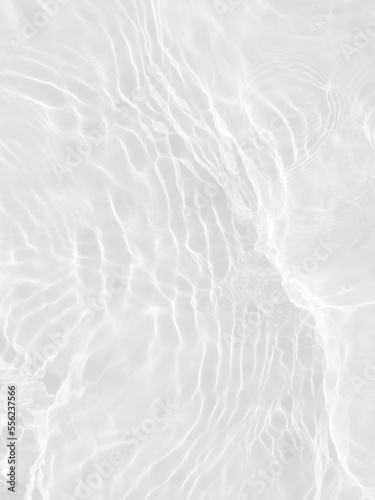 Defocus blurred transparent white colored clear calm water surface texture with splashes and bubbles. Trendy abstract nature background. Water waves in sunlight with copy space. White water shine