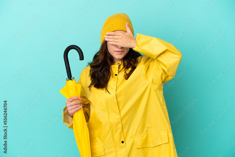 Young caucasian man holding an umbrella isolated on blue background covering eyes by hands. Do not want to see something Young caucasian man holding an umbrella isolated on blue background covering eyes by hands. Do not want to see something