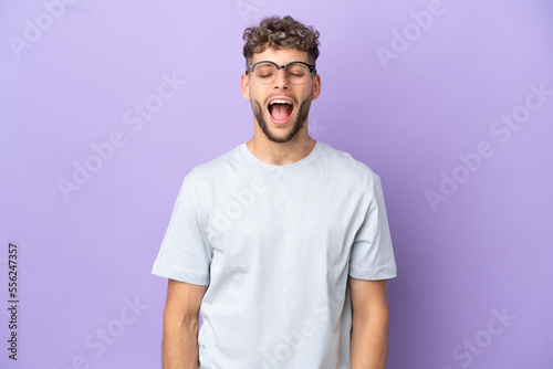 Delivery caucasian man isolated on purple background shouting to the front with mouth wide open