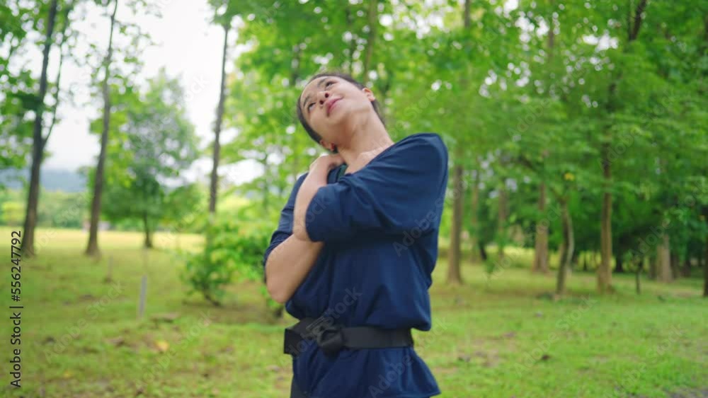 Happy fit asian woman enjoys resting after jogging in the green beautiful nature woods forest. Concept of female healthy natural lifestyle, happiness emotion, adult lady stretching neck shoulder arms Happy fit asian woman enjoys resting after jogging in the green beautiful nature woods forest. Concept of female healthy natural lifestyle, happiness emotion, adult lady stretching neck shoulder arms