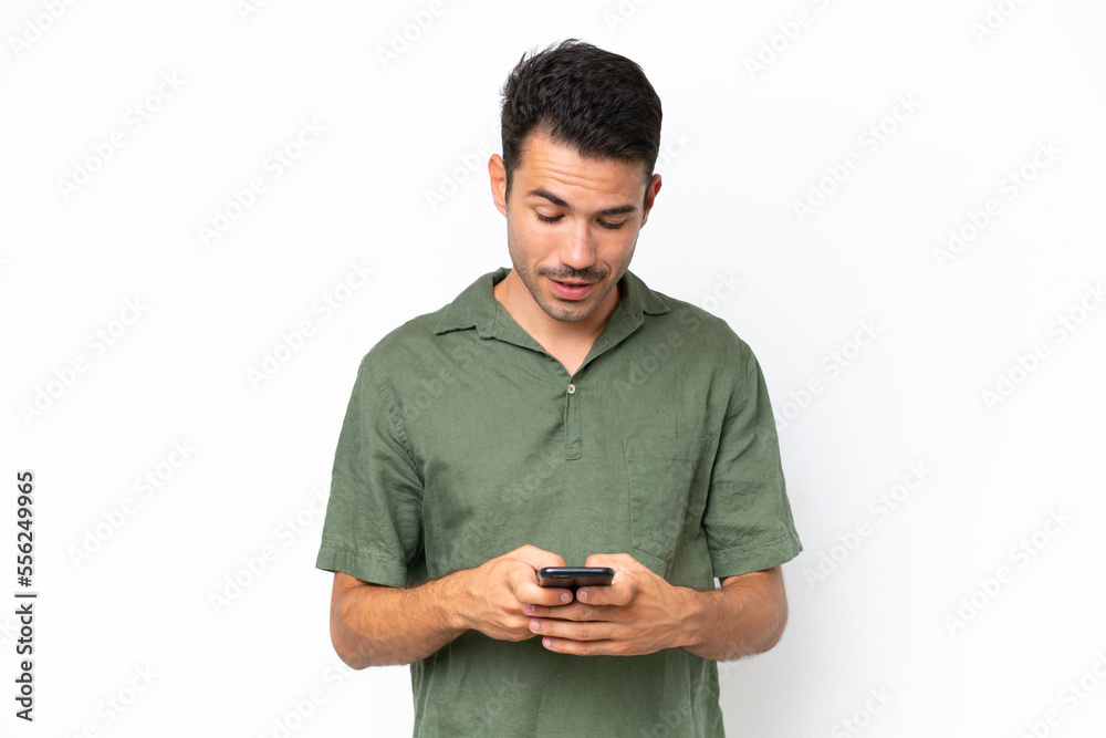Young handsome man over isolated white background sending a message with the mobile Young handsome man over isolated white background sending a message with the mobile
