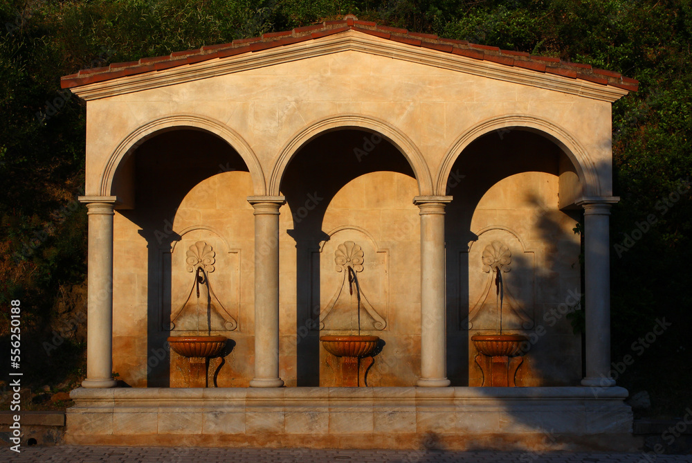 Last rays of sunlight on a spring evening. Three fountains under the arches of a wash-house, boulevard St Michel, in Lamalou-les-Bains (Hérault, France) 