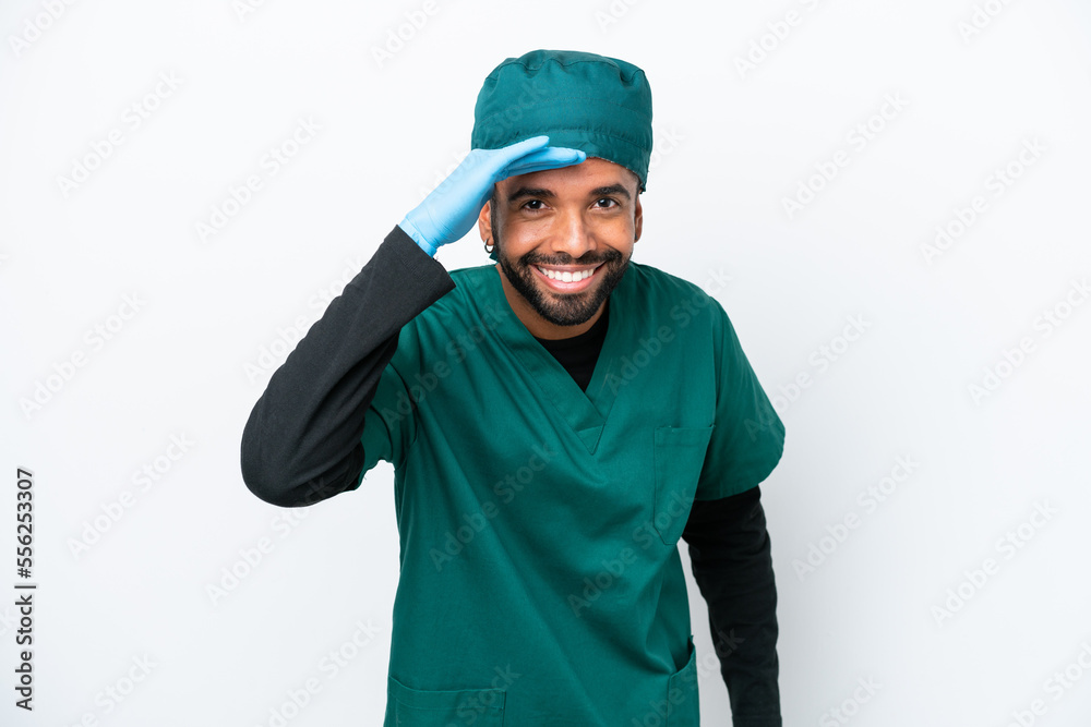 Surgeon Brazilian man in green uniform isolated on white background looking far away with hand to look something Surgeon Brazilian man in green uniform isolated on white background looking far away with hand to look something