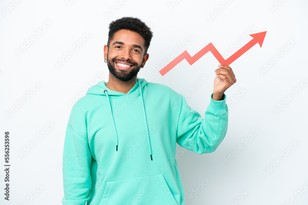 Young Brazilian man isolated on white background holding a catching a rising arrow with happy expression Young Brazilian man isolated on white background holding a catching a rising arrow with happy expression