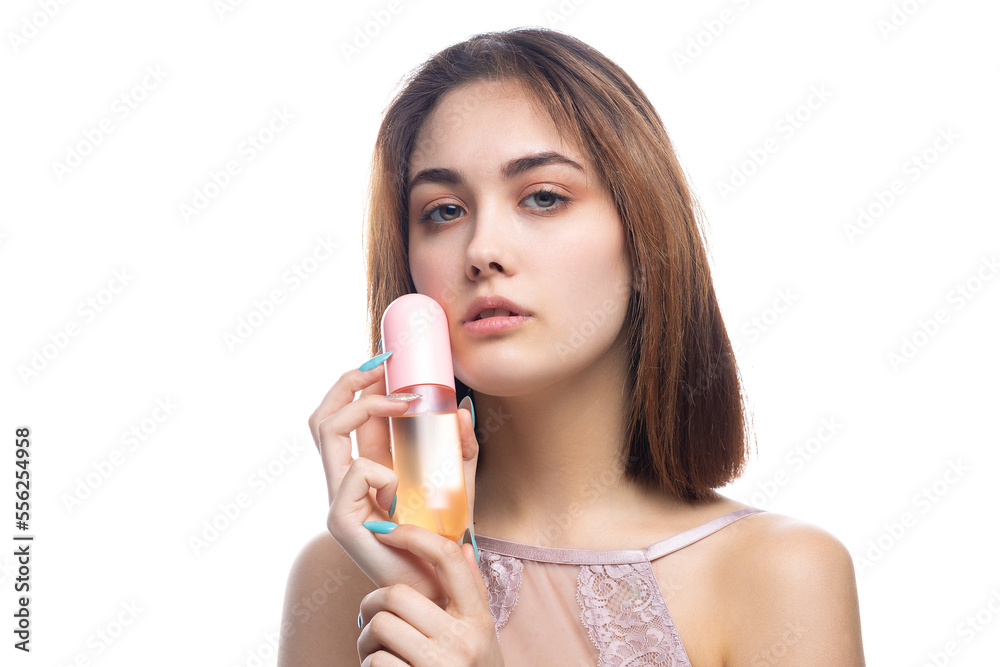 A beautiful sexy lady in an elegant nude bodysuit holds a bottle in her hands. Fashion beauty portrait of fashion model girl on isolated white background. A beautiful sexy lady in an elegant nude bodysuit holds a bottle in her hands. Fashion beauty portrait of fashion model girl on isolated white background.