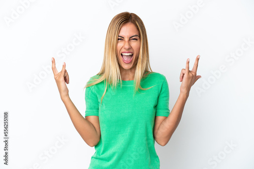 Blonde Uruguayan girl isolated on white background making horn gesture photo