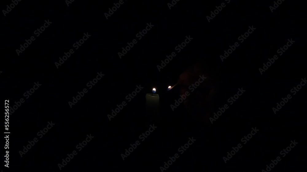 lighting a candle from a match. candles in the dark. candles for the night. light in the night lighting a candle from a match. candles in the dark. candles for the night. light in the night