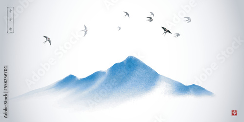 Swallows flying over the blue mountain. Traditional oriental ink painting sumi-e  u-sin  go-hua. Hieroglyph - happiness.