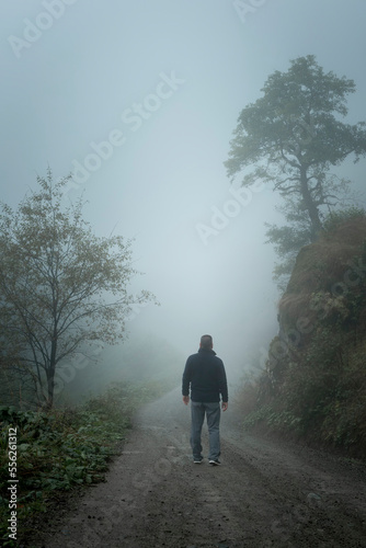 man walking in foggy forest