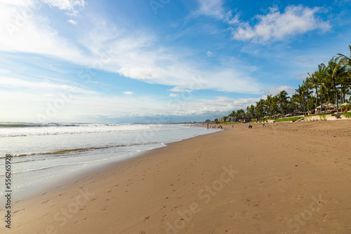 BALI, INDONESIA - OCTOBER 29, 2022: People walking on Petitenget beach with modern and expensive restaurants and hotels photo