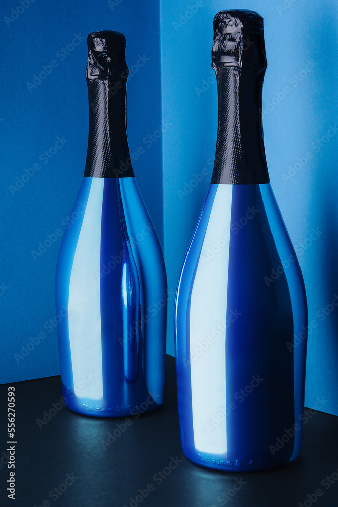 two blue bottles of champagne on blue background two blue bottles of champagne on blue background