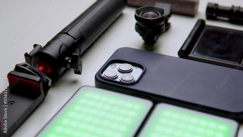 Equipment for shooting video on a smartphone. Microphone, LED lamp, tripod, lens smartphone are on a white table