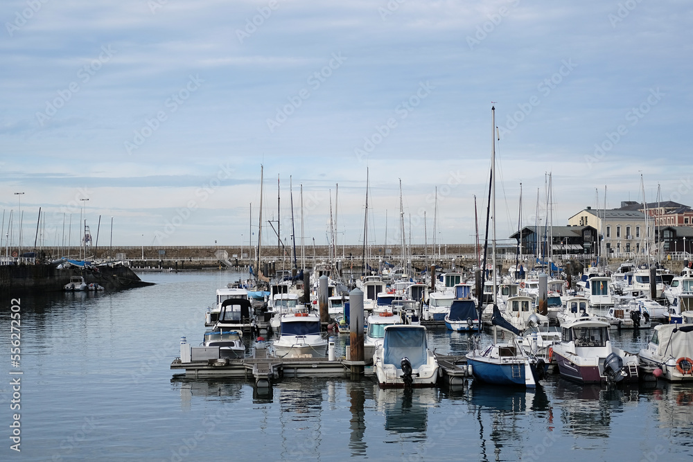 Fototapeta premium View of the Gijon marina in the port. Calm sea, reflection of yachts and boats in the water. Boats anchored in Gijon in the old town of Northern Spain, touristic place