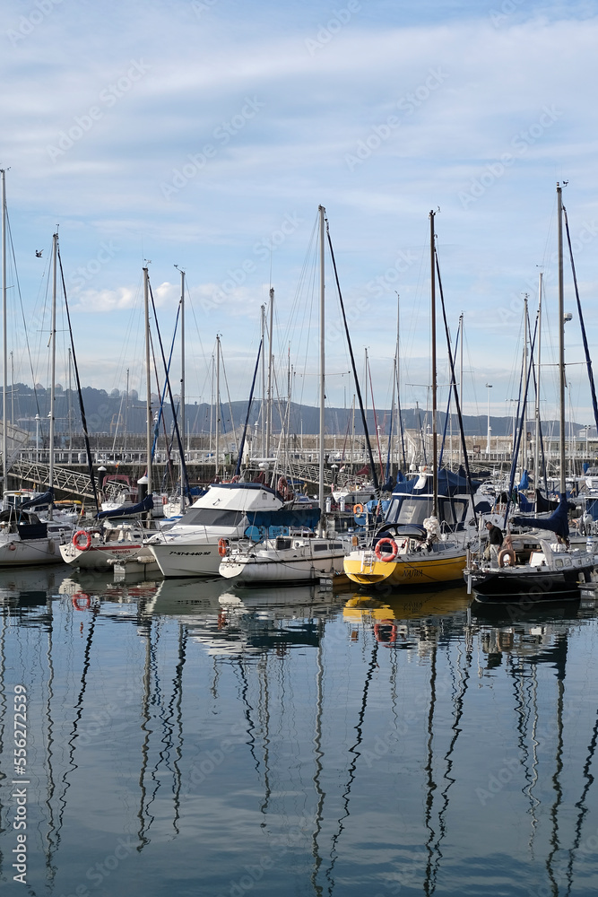 View of the Gijon marina in the port. Calm sea, reflection of yachts and boats in the water. Boats anchored in Gijon in the old town of Northern Spain, touristic place