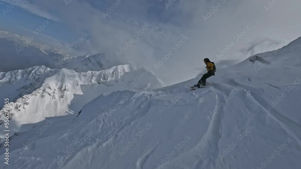 Fpv drone follow around man riding snowboard freeride trick ridge mountain ridge snowy splash slope extreme sport leisure activity aerial view. Snowboarding rider jumping cliff peak freestyle hobby 4k