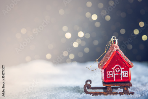 Christmas tree toy in the form of a red house on a sleigh in the snow. christmas, new year background