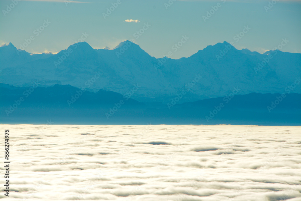 Panoramic view of Eiger, Mönch and Jungfrau in the Swiss Alps, above a sea of clouds and fog, view from Röti peak in Solothurn Jura, Switzerland