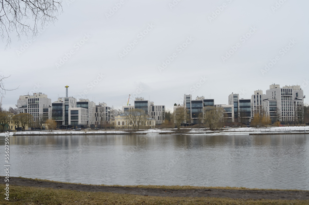 Obraz premium A view from the river bank to multi -storey beautiful buildings in a modern single style