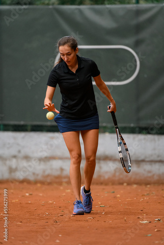 Close-up of woman on court and holding tennis ball while preparing for serving tennis ball © fesenko