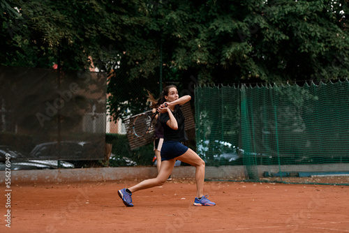view of sports female tennis player with racket ready to hit tennis ball flying towards her. © fesenko