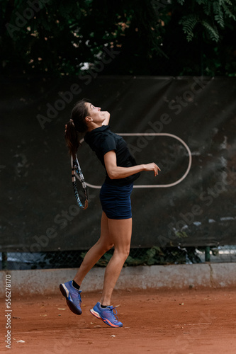 active adult female tennis player with tennis racket in her hand behind her back © fesenko