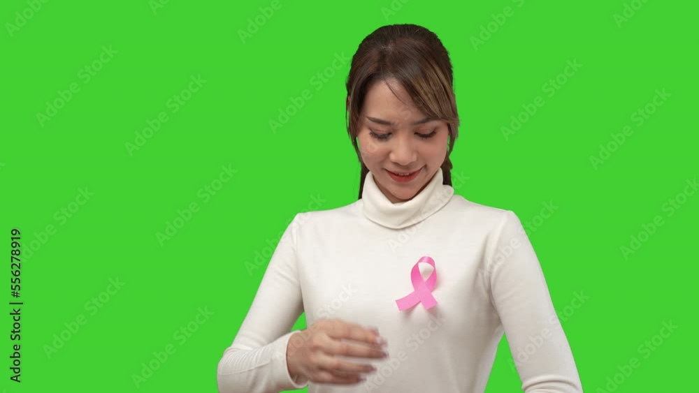 Breast Cancer. Beautiful woman stuck pink ribbon symbolizing World Cancer Day on the chest. Isolated green screen background. Breast Cancer. Beautiful woman stuck pink ribbon symbolizing World Cancer Day on the chest. Isolated green screen background.